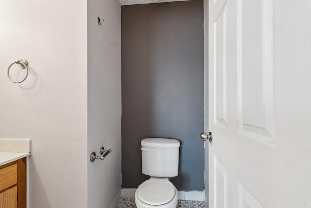 bathroom with tile patterned floors, baseboards, toilet, and vanity