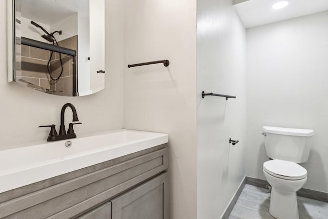 bathroom featuring vanity, wood finished floors, baseboards, walk in shower, and toilet