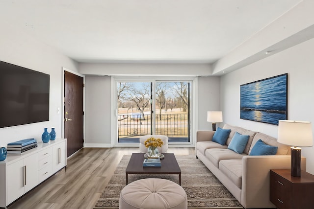 living room featuring light wood-type flooring and baseboards