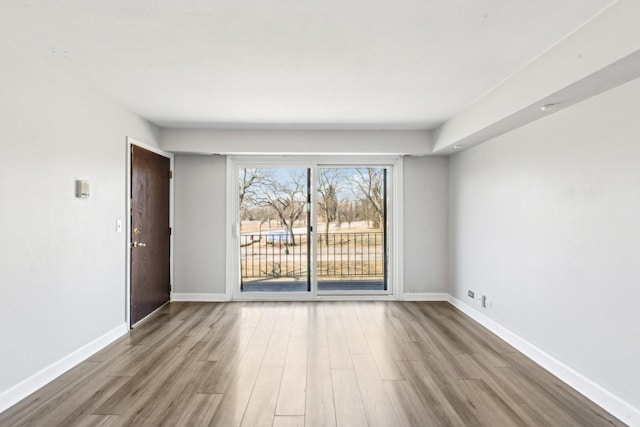 unfurnished room with baseboards and wood finished floors