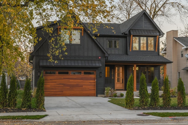 view of front of house with board and batten siding, concrete driveway, a garage, and roof with shingles