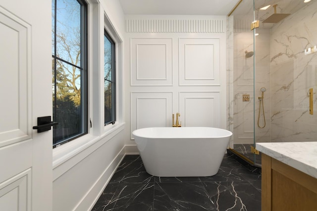 bathroom featuring vanity, marble finish floor, a marble finish shower, and a freestanding bath