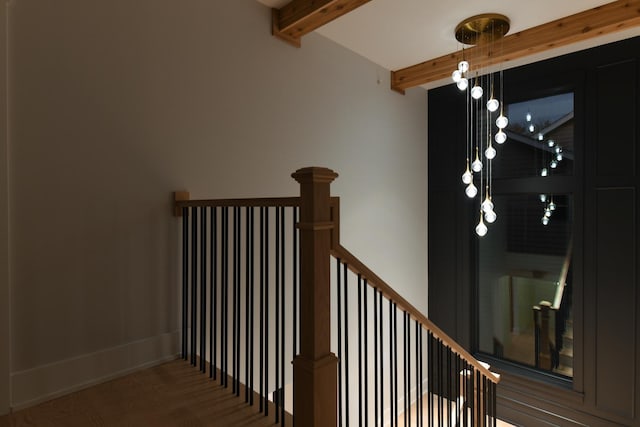 staircase with beam ceiling and baseboards