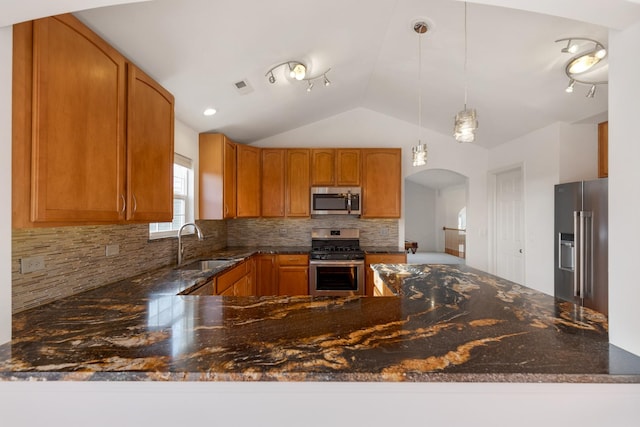 kitchen featuring visible vents, stainless steel appliances, dark stone counters, decorative backsplash, and vaulted ceiling