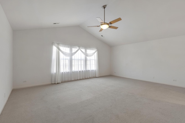 empty room featuring visible vents, light carpet, high vaulted ceiling, a ceiling fan, and baseboards