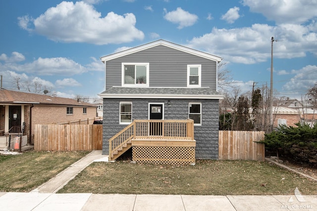 view of front of house with a wooden deck, roof with shingles, and fence