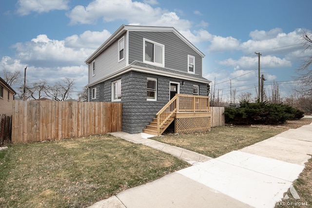 view of front of home with a front yard and fence