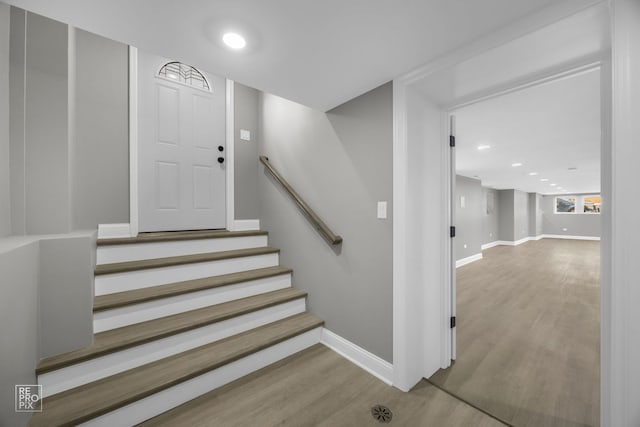 staircase with recessed lighting, wood finished floors, and baseboards