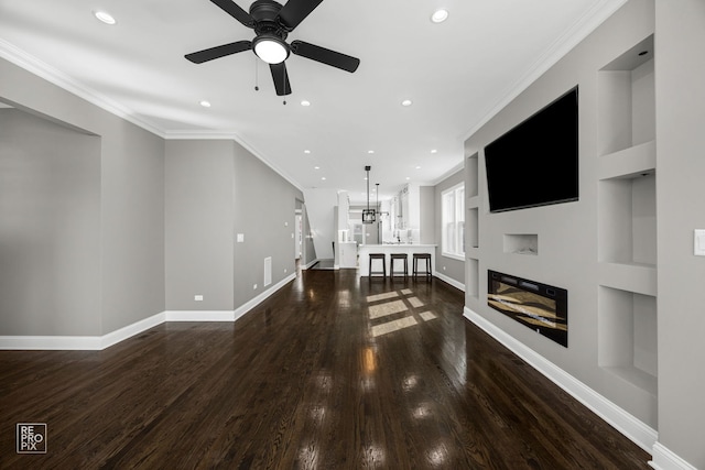 unfurnished living room with crown molding and built in features