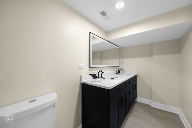 bathroom featuring a sink, visible vents, baseboards, and toilet