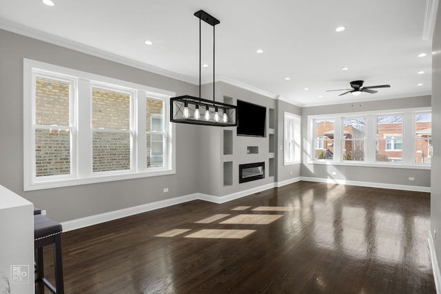 unfurnished living room with wood finished floors, a ceiling fan, baseboards, recessed lighting, and ornamental molding