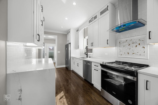 kitchen featuring ornamental molding, a sink, appliances with stainless steel finishes, wall chimney exhaust hood, and dark wood-style flooring