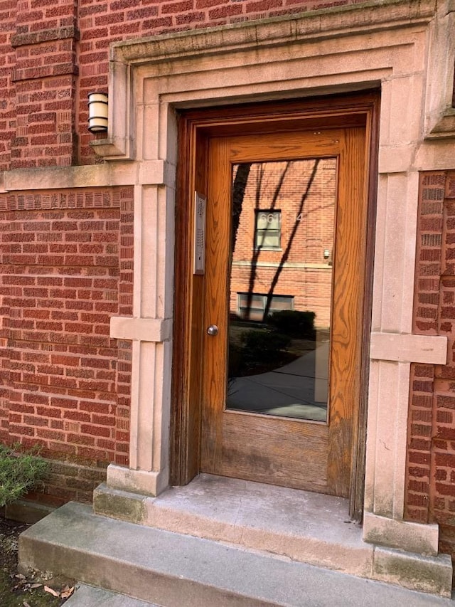 entrance to property featuring brick siding