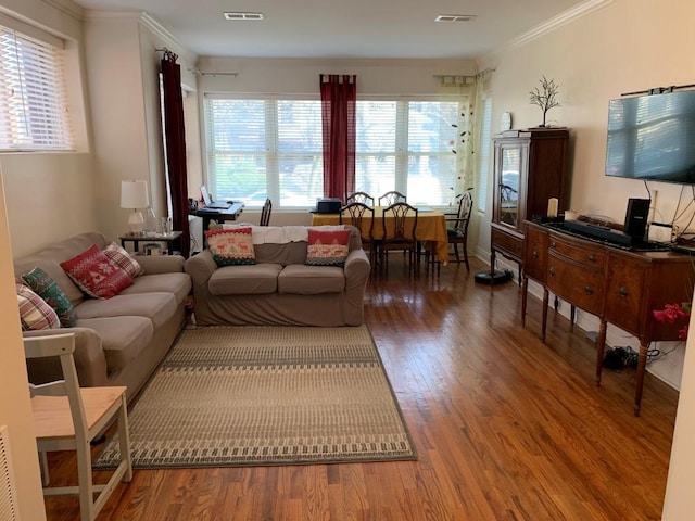 living room featuring visible vents, crown molding, and wood finished floors