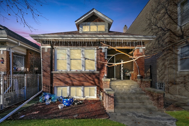 rear view of house featuring brick siding and fence