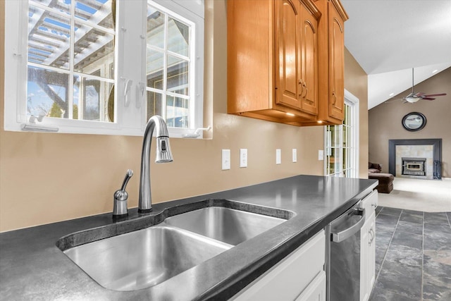 3402 Mill Creek Ct, Champaign, IL 61822 - kitchen featuring stainless steel dishwasher, brown cabinetry, a ceiling fan, dark countertops, and a sink