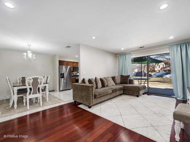 living area with recessed lighting, visible vents, a notable chandelier, and light wood finished floors