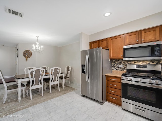 kitchen featuring visible vents, marble finish floor, tasteful backsplash, appliances with stainless steel finishes, and brown cabinetry