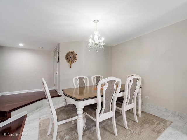 dining area with baseboards, marble finish floor, and an inviting chandelier