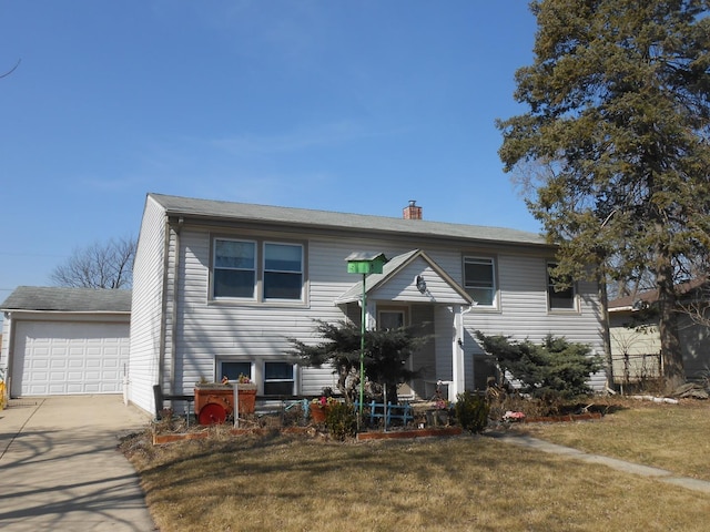 raised ranch with a front lawn, a garage, and a chimney