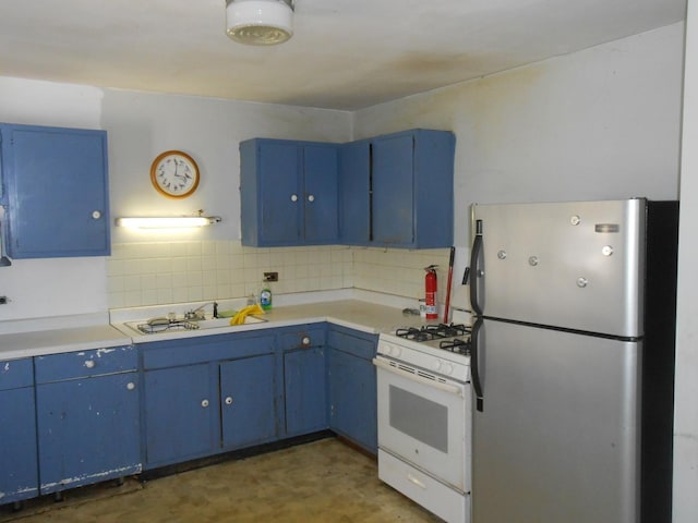 kitchen with tasteful backsplash, white range with gas cooktop, freestanding refrigerator, blue cabinets, and a sink