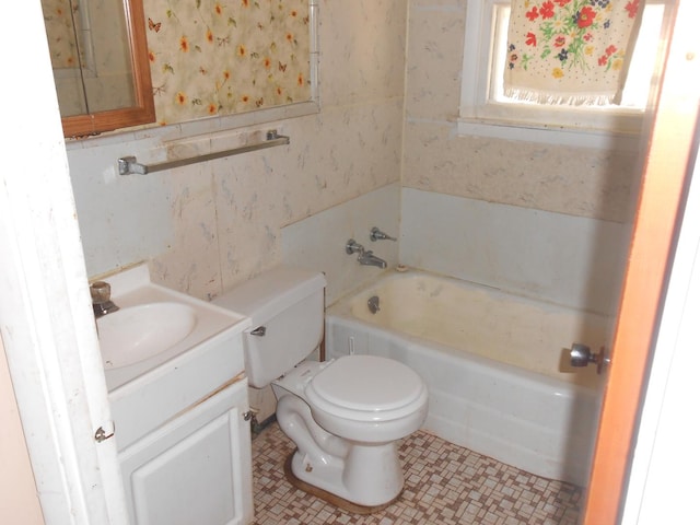 bathroom with wallpapered walls, toilet, vanity, and a bathing tub