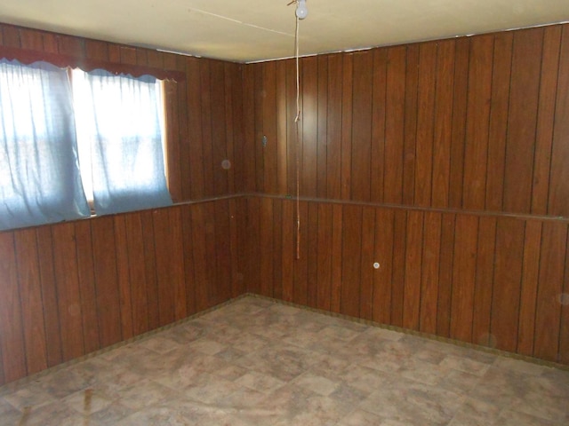 empty room with tile patterned floors and wood walls