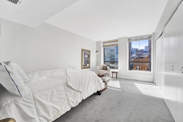 carpeted bedroom with visible vents and a city view