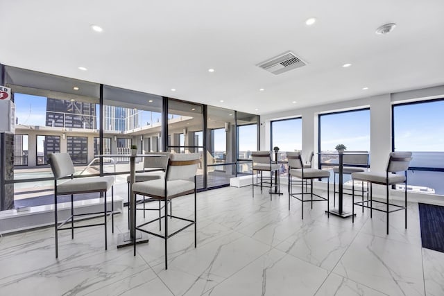 dining space featuring recessed lighting, visible vents, marble finish floor, and expansive windows