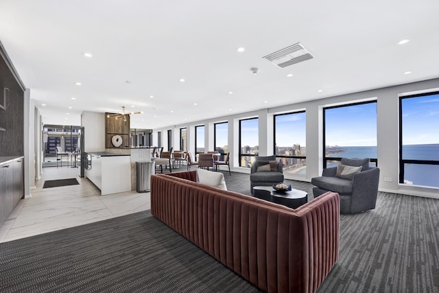 living area with recessed lighting, visible vents, and marble finish floor