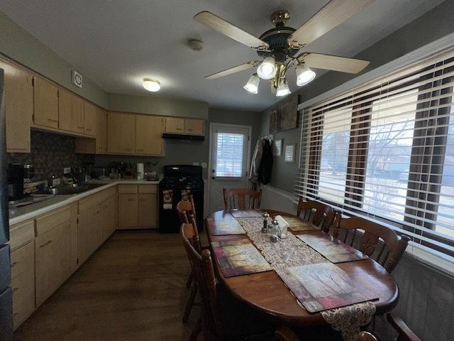 kitchen with black gas stove, light countertops, decorative backsplash, exhaust hood, and a ceiling fan