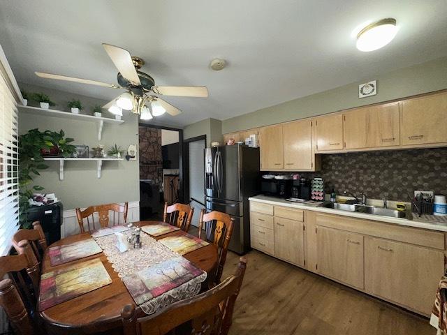 kitchen featuring a ceiling fan, light brown cabinetry, a sink, freestanding refrigerator, and light countertops