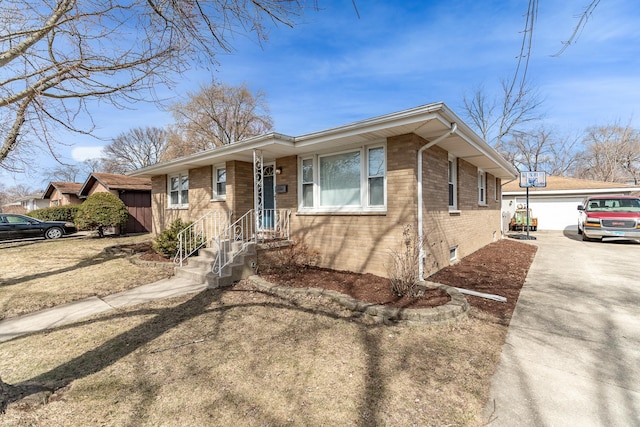 view of front of home with a detached garage, brick siding, and an outdoor structure