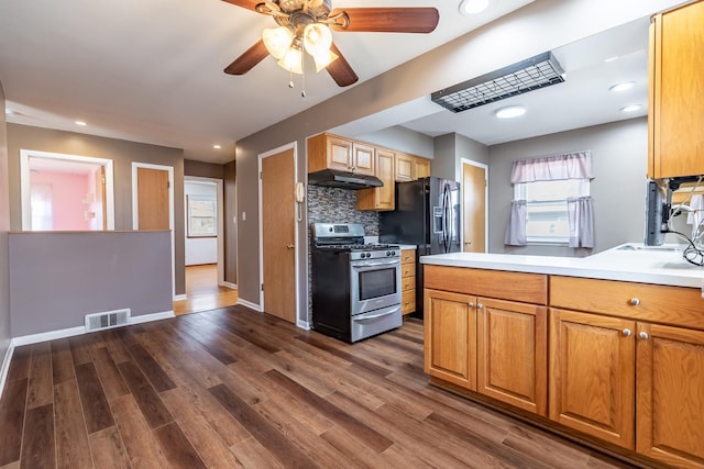 kitchen with a ceiling fan, gas stove, visible vents, dark wood-type flooring, and under cabinet range hood