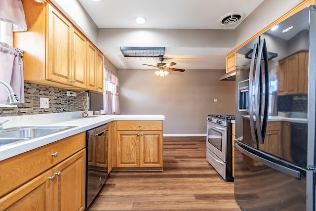 kitchen featuring stainless steel gas range oven, visible vents, dishwasher, black fridge, and a ceiling fan