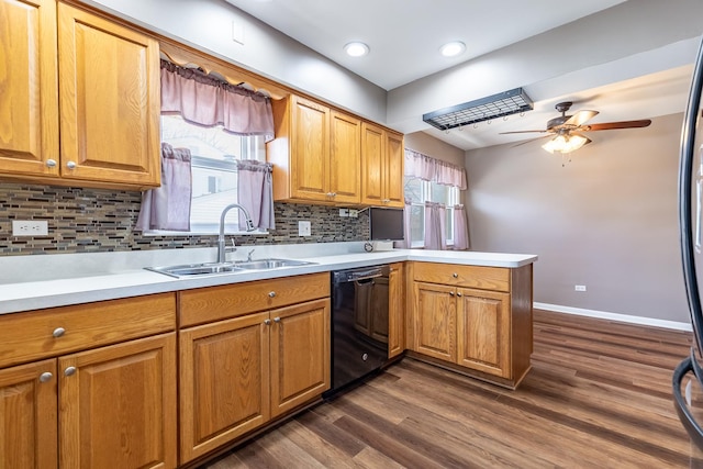 kitchen with a peninsula, a sink, decorative backsplash, light countertops, and dishwasher