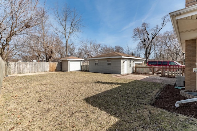 view of yard featuring an outbuilding, a garage, and a fenced backyard