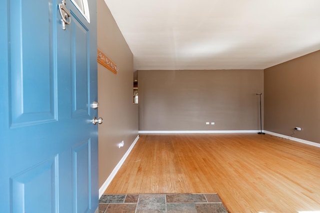 entryway with baseboards and wood finished floors