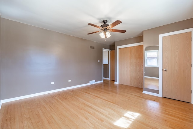 unfurnished bedroom featuring visible vents, light wood-style flooring, and baseboards