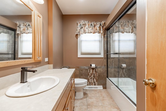 full bathroom with vanity, tile patterned floors, toilet, and bath / shower combo with glass door