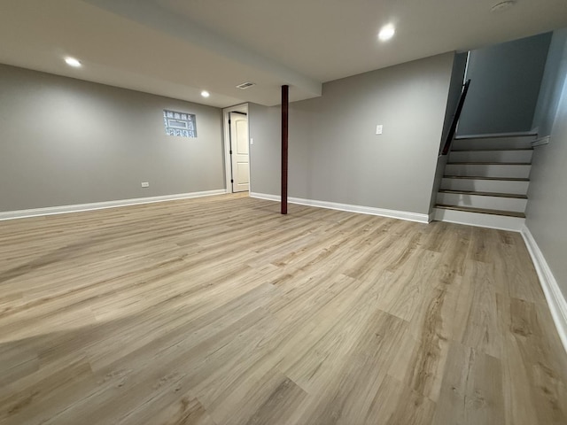 finished below grade area featuring stairway, visible vents, baseboards, recessed lighting, and light wood-type flooring