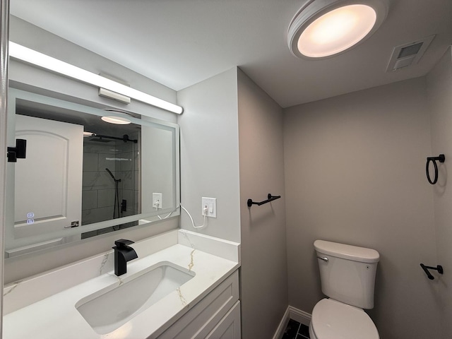 full bathroom featuring a tile shower, visible vents, toilet, and vanity