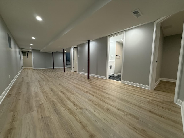 finished below grade area featuring recessed lighting, visible vents, baseboards, and light wood-style flooring