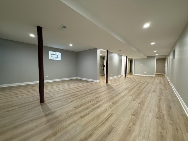 finished below grade area with recessed lighting, baseboards, visible vents, and light wood-type flooring