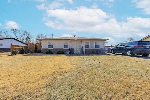 ranch-style home with brick siding, a front lawn, and fence