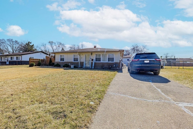 ranch-style house featuring brick siding, a front lawn, and fence