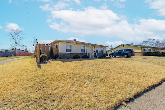 single story home featuring brick siding, a front lawn, and fence