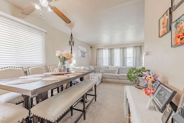 dining space featuring a ceiling fan and light carpet