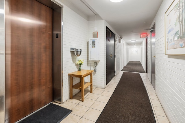 corridor with elevator and light tile patterned flooring