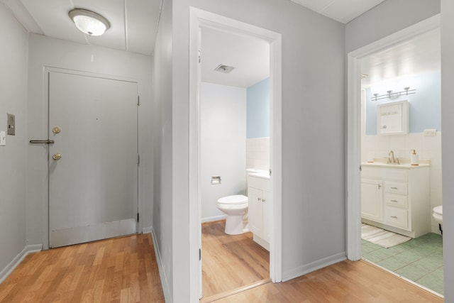 bathroom featuring visible vents, toilet, wood finished floors, and vanity